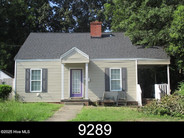 504 E 2nd St, Greenville, NC 27858 - new england style home featuring a chimney, a shingled roof, and a front lawn