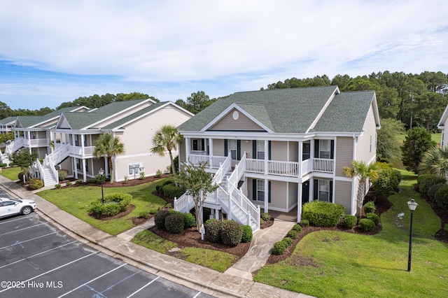 964 Great Egret Cir SW Unit 32B, Sunset Beach, NC 28468 - view of front of property with a porch, stairway, uncovered parking, roof with shingles, and a front lawn