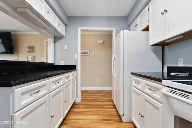 11 Foxfire Trce, Oak Island, NC 28465 - kitchen with white cabinetry, light wood-style flooring, white appliances, and dark countertops