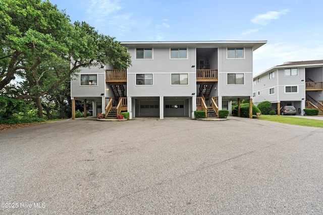 11 Foxfire Trce, Oak Island, NC 28465 - view of building exterior featuring stairway, driveway, a garage, and a carport