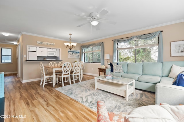 11 Foxfire Trce, Oak Island, NC 28465 - living room featuring ornamental molding, light wood-style floors, a chandelier, and ceiling fan