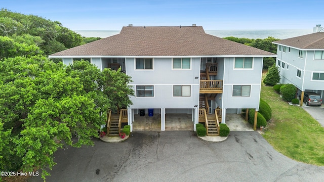 11 Foxfire Trce, Oak Island, NC 28465 - view of building exterior featuring stairway, a carport, driveway, and a water view
