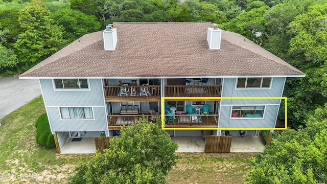 11 Foxfire Trce, Oak Island, NC 28465 - rear view of property featuring a chimney, a balcony, a shingled roof, and a patio