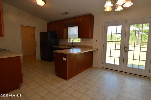 140 Van Riggs Rd, Hubert, NC 28539 - kitchen with freestanding refrigerator, a peninsula, light floors, light countertops, and a chandelier