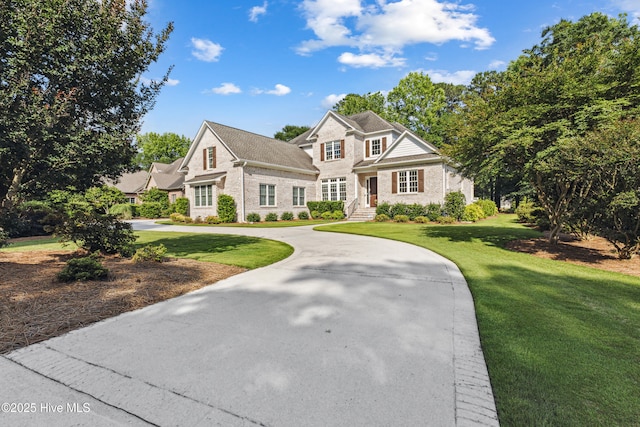 8812 Fazio Dr, Wilmington, NC 28411 - view of front of property featuring a front lawn, brick siding, and curved driveway