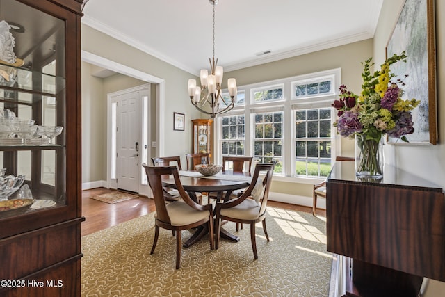 8812 Fazio Dr, Wilmington, NC 28411 - dining space featuring a chandelier, ornamental molding, and wood finished floors