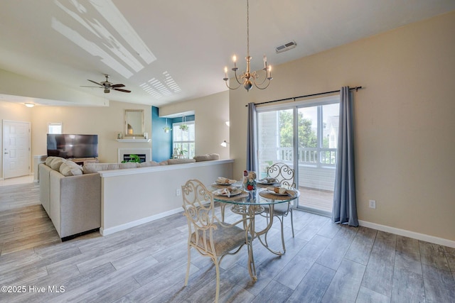 213 Fullford Ln Unit 201, Wilmington, NC 28412 - dining space featuring light wood-style floors, ceiling fan, a chandelier, a fireplace, and lofted ceiling