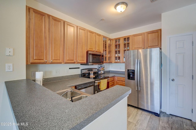 213 Fullford Ln Unit 201, Wilmington, NC 28412 - kitchen with appliances with stainless steel finishes, glass insert cabinets, dark countertops, light wood-style floors, and a peninsula