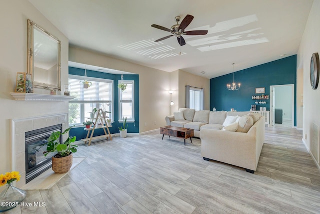 213 Fullford Ln Unit 201, Wilmington, NC 28412 - living room with lofted ceiling, wood finished floors, a tiled fireplace, a chandelier, and a ceiling fan