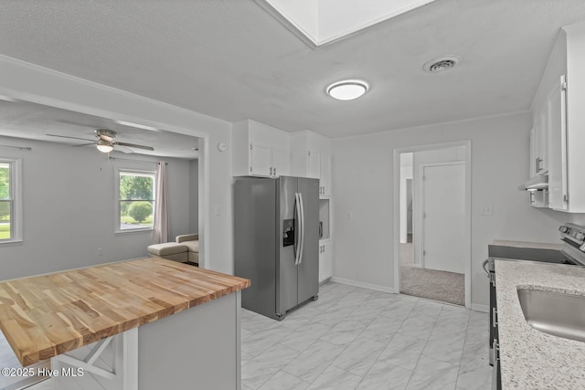 1292 Lake Cole Rd, Midway Park, NC 28544 - kitchen featuring stainless steel appliances, under cabinet range hood, light marble finish flooring, white cabinets, and plenty of natural light