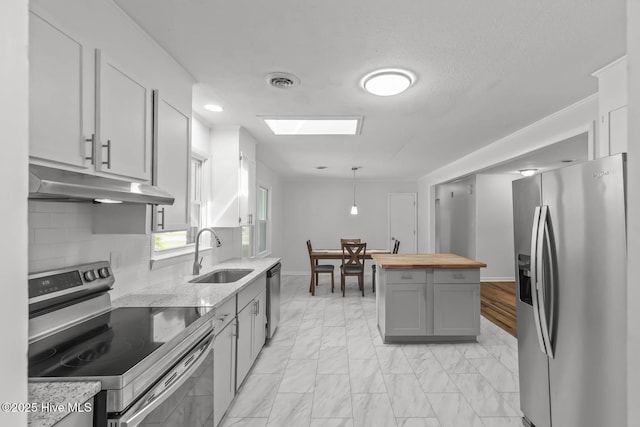 1292 Lake Cole Rd, Midway Park, NC 28544 - kitchen with appliances with stainless steel finishes, wood counters, under cabinet range hood, gray cabinetry, and decorative backsplash