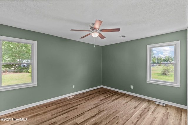 1292 Lake Cole Rd, Midway Park, NC 28544 - unfurnished room featuring wood finished floors, plenty of natural light, ceiling fan, and a textured ceiling