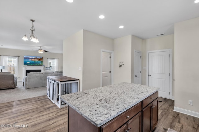 324 Windmill Light Way, Sneads Ferry, NC 28460 - kitchen featuring a chandelier, light wood finished floors, decorative light fixtures, a fireplace, and recessed lighting