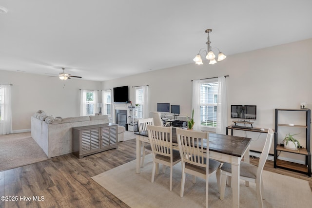 324 Windmill Light Way, Sneads Ferry, NC 28460 - dining space with wood finished floors, a glass covered fireplace, a chandelier, and ceiling fan