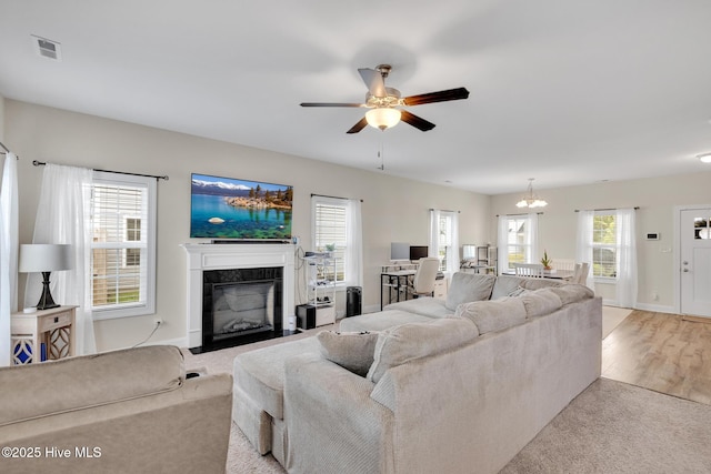 324 Windmill Light Way, Sneads Ferry, NC 28460 - living room featuring a fireplace, ceiling fan, plenty of natural light, and a chandelier