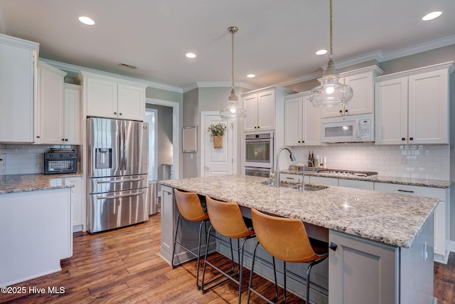 110 E Conolly Ct, Hampstead, NC 28443 - kitchen with white appliances, ornamental molding, tasteful backsplash, white cabinetry, and wood finished floors