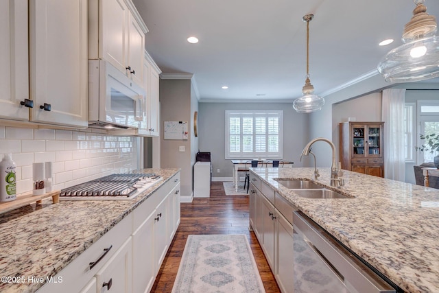 110 E Conolly Ct, Hampstead, NC 28443 - kitchen with white microwave, dishwasher, crown molding, dark wood finished floors, and backsplash