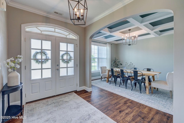 110 E Conolly Ct, Hampstead, NC 28443 - foyer entrance featuring a chandelier, arched walkways, ornamental molding, dark wood-type flooring, and beam ceiling