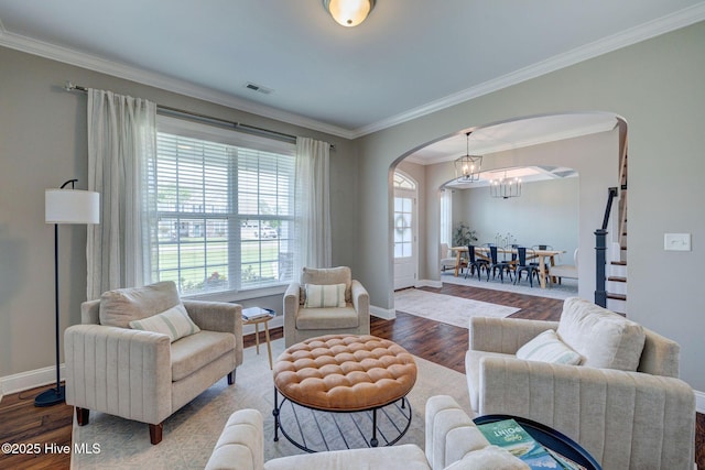 110 E Conolly Ct, Hampstead, NC 28443 - living room with arched walkways, wood finished floors, ornamental molding, and a chandelier