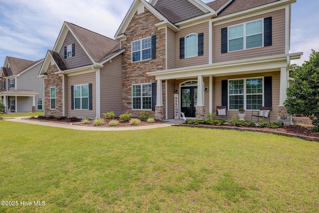 110 E Conolly Ct, Hampstead, NC 28443 - craftsman inspired home featuring stone siding, a front lawn, french doors, and covered porch