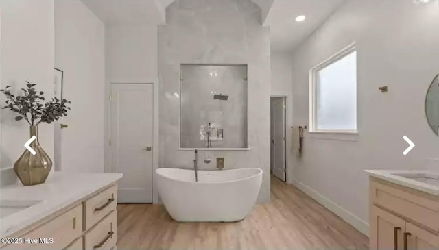 209 Planters Ridge Dr, Sunset Beach, NC 28468 - full bathroom featuring wood finished floors, two vanities, a soaking tub, and a walk in shower