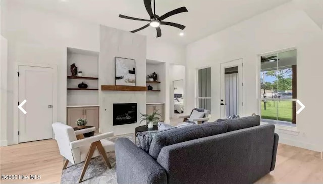 209 Planters Ridge Dr, Sunset Beach, NC 28468 - living room featuring ceiling fan, light wood-type flooring, a fireplace, built in features, and a high ceiling