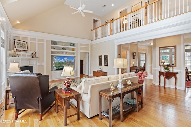 2710 Scarborough Way, Southport, NC 28461 - living area with high vaulted ceiling, ceiling fan, built in shelves, and light wood-style flooring