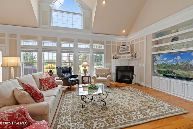 2710 Scarborough Way, Southport, NC 28461 - living room featuring plenty of natural light, high vaulted ceiling, a premium fireplace, and wood finished floors