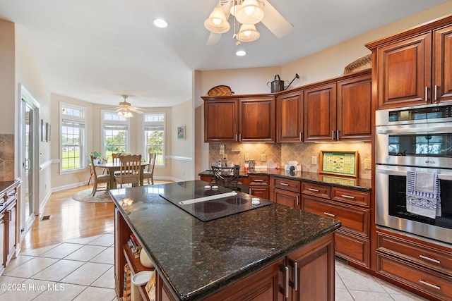 2710 Scarborough Way, Southport, NC 28461 - kitchen with a ceiling fan, double oven, light tile patterned floors, backsplash, and black electric stovetop