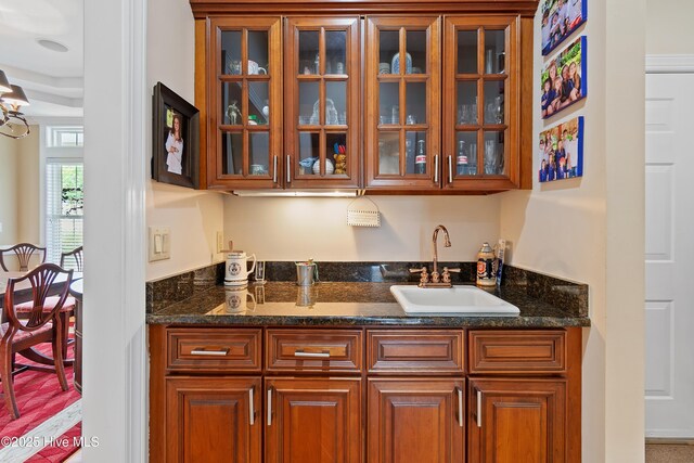 2710 Scarborough Way, Southport, NC 28461 - kitchen featuring glass insert cabinets, brown cabinets, and dark stone counters