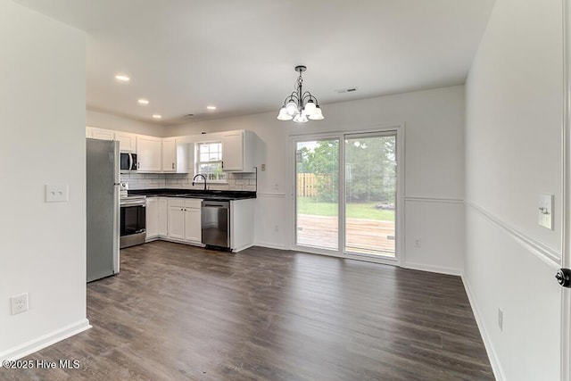 2604 Larne Ct, Wilmington, NC 28411 - kitchen featuring stainless steel appliances, a chandelier, dark countertops, dark wood-style floors, and recessed lighting