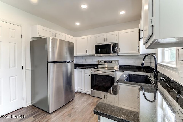 2604 Larne Ct, Wilmington, NC 28411 - kitchen featuring stainless steel appliances, dark stone countertops, white cabinetry, light wood-style floors, and recessed lighting