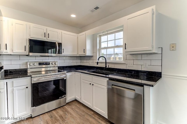 2604 Larne Ct, Wilmington, NC 28411 - kitchen featuring stainless steel appliances, white cabinets, tasteful backsplash, wood finished floors, and recessed lighting