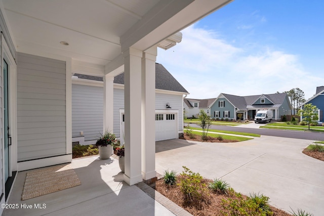 523 Trisail Ter, Wilmington, NC 28412 - view of patio with a garage, driveway, and a residential view