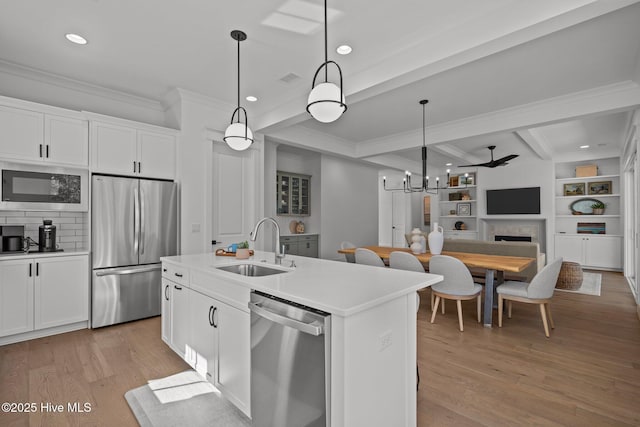 523 Trisail Ter, Wilmington, NC 28412 - kitchen featuring appliances with stainless steel finishes, crown molding, light wood-style flooring, beamed ceiling, and white cabinetry