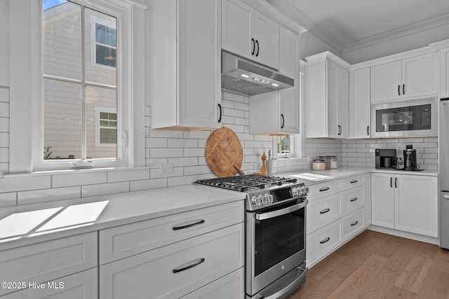 523 Trisail Ter, Wilmington, NC 28412 - kitchen with stainless steel gas range, under cabinet range hood, built in microwave, white cabinets, and crown molding