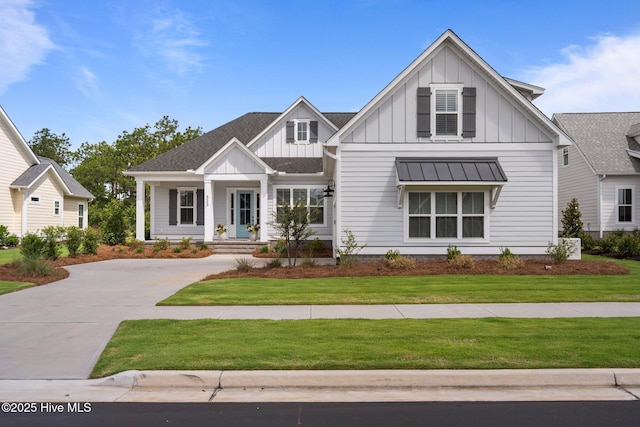 523 Trisail Ter, Wilmington, NC 28412 - modern farmhouse featuring board and batten siding, a front lawn, driveway, and a standing seam roof