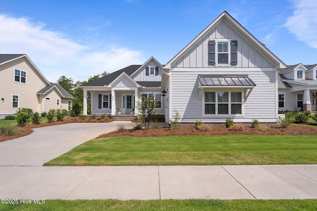 523 Trisail Ter, Wilmington, NC 28412 - modern inspired farmhouse featuring board and batten siding, a standing seam roof, a front yard, and driveway