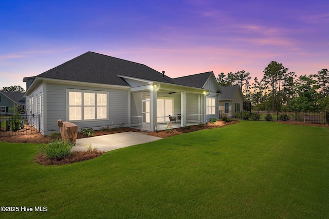 523 Trisail Ter, Wilmington, NC 28412 - back of house at dusk with a ceiling fan, a patio, a sunroom, and a shingled roof
