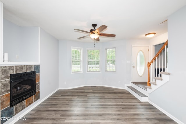115 Billets Bridge Rd, Camden, NC 27921 - unfurnished living room with a ceiling fan, heating unit, stairway, a tile fireplace, and wood finished floors