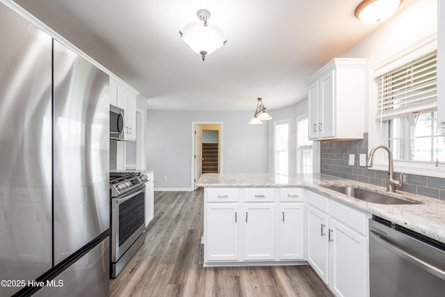 115 Billets Bridge Rd, Camden, NC 27921 - kitchen featuring stainless steel appliances, a peninsula, white cabinets, and backsplash