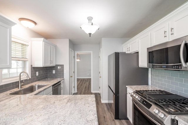 115 Billets Bridge Rd, Camden, NC 27921 - kitchen with appliances with stainless steel finishes, white cabinetry, dark wood-style flooring, backsplash, and light stone counters
