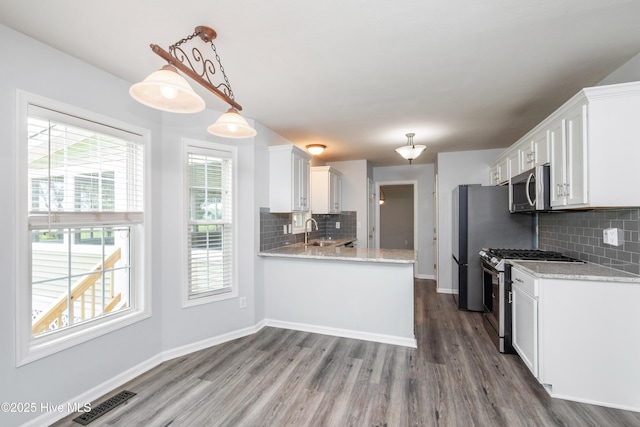 115 Billets Bridge Rd, Camden, NC 27921 - kitchen featuring appliances with stainless steel finishes, white cabinets, wood finished floors, and plenty of natural light