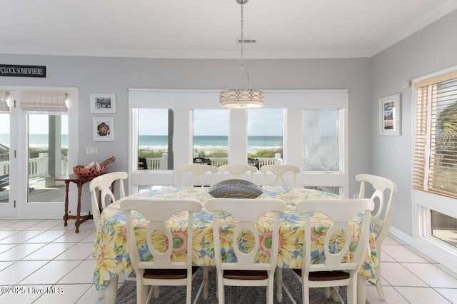 887 Ocean Blvd W, Holden Beach, NC 28462 - dining space featuring light tile patterned floors, crown molding, and a water view