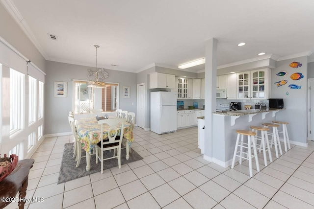 887 Ocean Blvd W, Holden Beach, NC 28462 - kitchen with white appliances, a breakfast bar area, a peninsula, glass insert cabinets, and light tile patterned floors