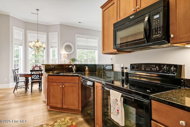428 Windchime Dr, Wilmington, NC 28412 - kitchen with black appliances, a chandelier, brown cabinets, light wood finished floors, and a peninsula