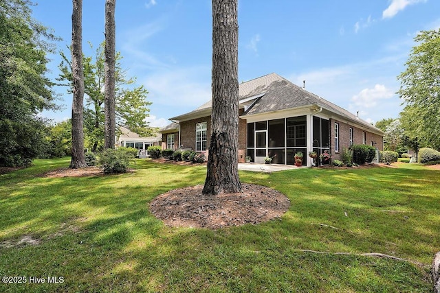 428 Windchime Dr, Wilmington, NC 28412 - back of house featuring a sunroom, a lawn, and brick siding