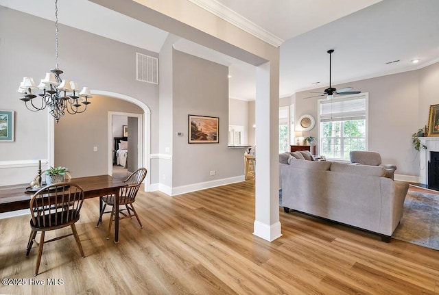 428 Windchime Dr, Wilmington, NC 28412 - dining room with light wood finished floors, arched walkways, ornamental molding, a chandelier, and a ceiling fan
