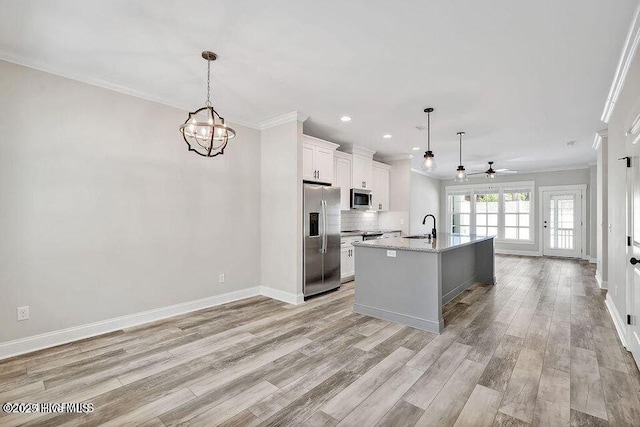 114 W 14th St Unit B, Southport, NC 28461 - kitchen featuring appliances with stainless steel finishes, ornamental molding, ceiling fan, a chandelier, and light wood-style floors