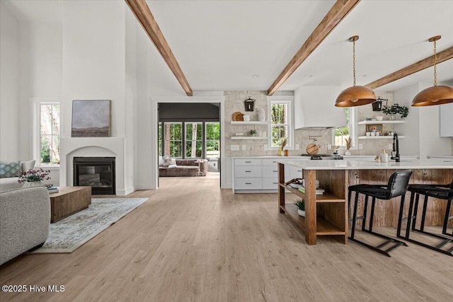 575 E Morganton Rd, Southern Pines, NC 28387 - living area with beam ceiling, light wood finished floors, and a glass covered fireplace
